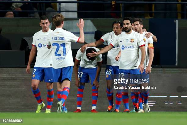 Robert Lewandowski of FC Barcelona celebrates scoring his team's first goal with teammates during the Super Copa de Espana Semi-Final match between...