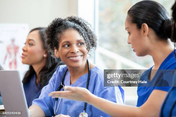 mature nurse attends medical conference or class with other healthcare workers to further education - further stock pictures, royalty-free photos & images
