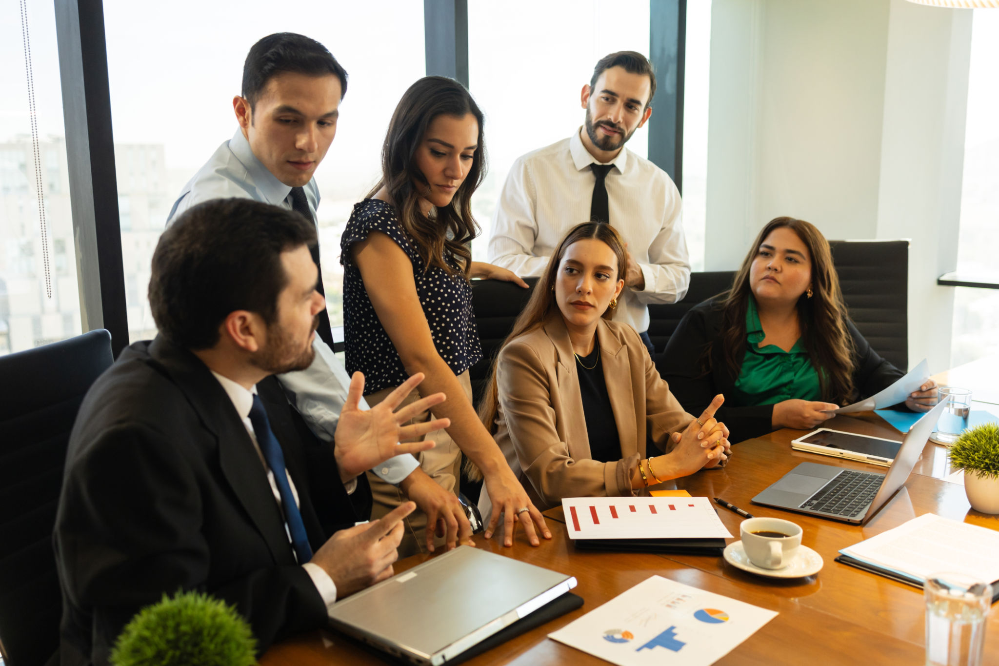 Group of businesspeople having a discussion in a meeting room and looking serious Group of businesspeople having a discussion in a meeting room and looking serious
