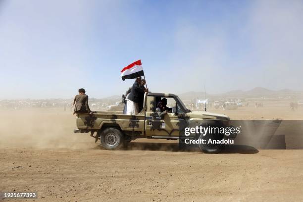 Members of different tribes shout anti-US slogans with guns in hands as they stage a protest against United States' attacks on Yemen's Houthis near...