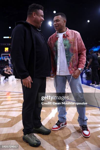 Footballer, Kylian Mbappe of France and former football player, Ronaldo #R9 speak at half time during NBA match between Brooklyn Nets and Cleveland...