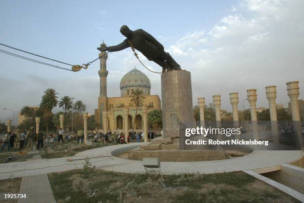 Iraqi civilians take down a Saddam Hussein statue with help from US Marines from the Marine 1st Division near the Palestine Hotel April 9, 2003 in...