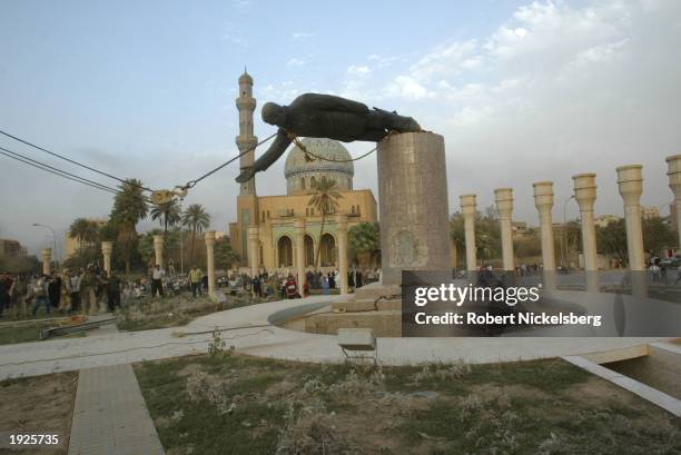 Iraqi civilians take down a Saddam Hussein statue with help from US Marines from the Marine 1st Division near the Palestine Hotel April 9, 2003 in...