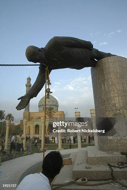 Iraqi civilians take down a Saddam Hussein statue with help from US Marines from the Marine 1st Division near the Palestine Hotel April 9, 2003 in...