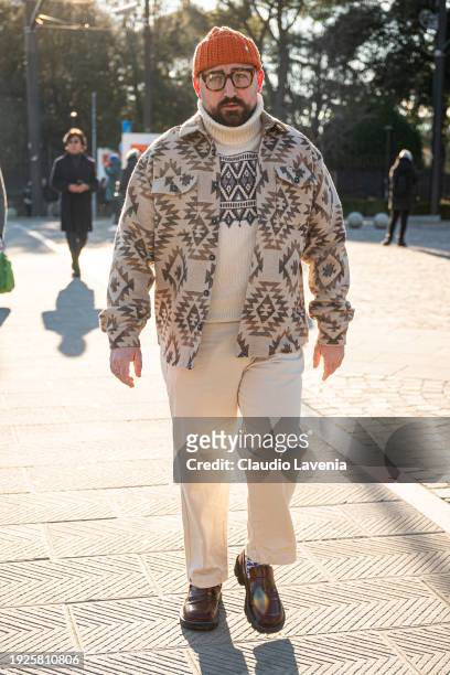 Christian Degennaro, wearing orange beanie and white turtleneck sweater and pants, is seen during Pitti Immagine Uomo 105 at Fortezza Da Basso on...