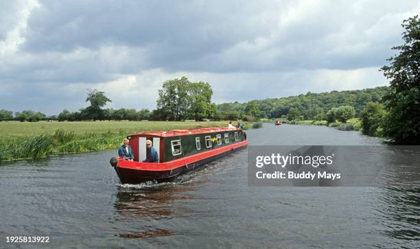 An English narrowboat navigates the Avon Canal, part of the Avon Ring, near Stratford-upon-Avon, England, 1985. .