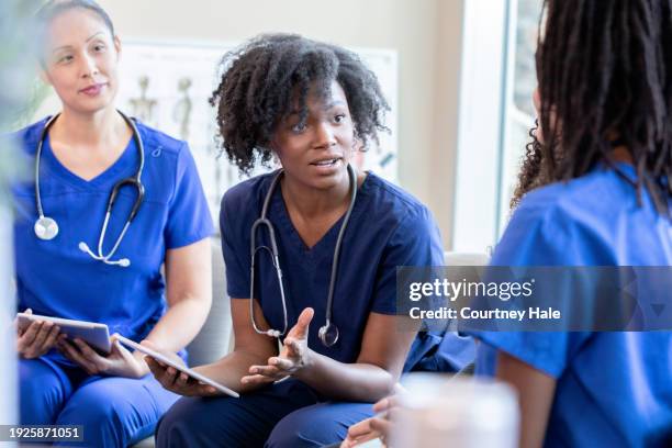 réunion du personnel médical diversifié à l’hôpital pour discuter du programme de soins infirmiers - suivi des malades photos et images de collection
