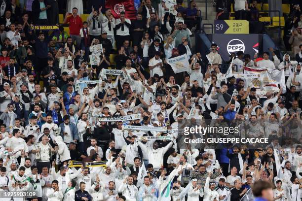Real Madrid fans cheer for their team before the start of the Spanish Super Cup final football match between Real Madrid and Barcelona at the...