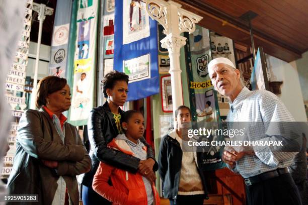 First lady Michelle Obama stands with her mother Marian Robinson, , and daughters Sasha and Malia as they listen to former resident Noor Ebrahim as...