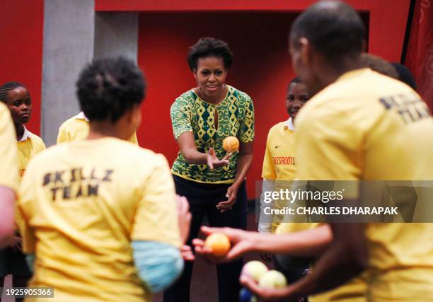 First Lady Michelle Obama celebrates as she participates in youth activities raising awareness for HIV prevention at Cape Town Stadium in Cape Town,...