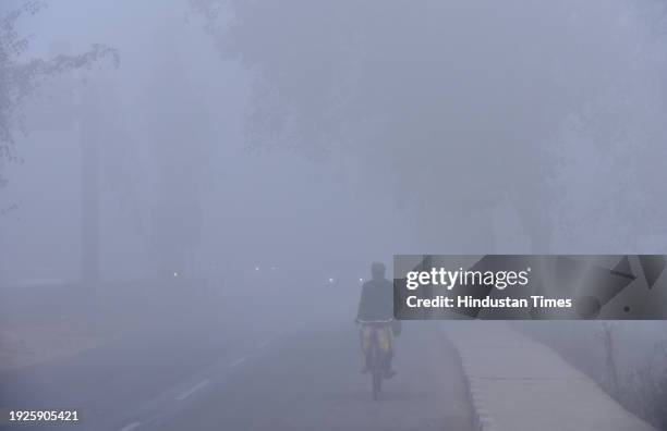 Vehicles moving slowly amid dense fog at NH9, Dasna on January 14, 2024 in Ghaziabad, India. Foggy morning challenges Delhi-NCR with intensifying...