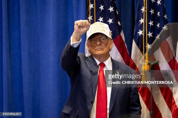 Former US President and 2024 Republican presidential hopeful Donald Trump raises his fist at a "Commit to Caucus" event at Simpson College in...