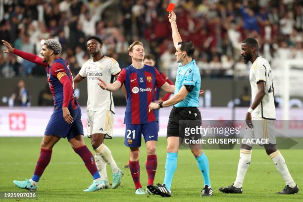 Spanish match referee Juan Martinez Munuera shows Barcelona's Uruguayan defender Ronald Araujo a red card during the Spanish Super Cup final football...