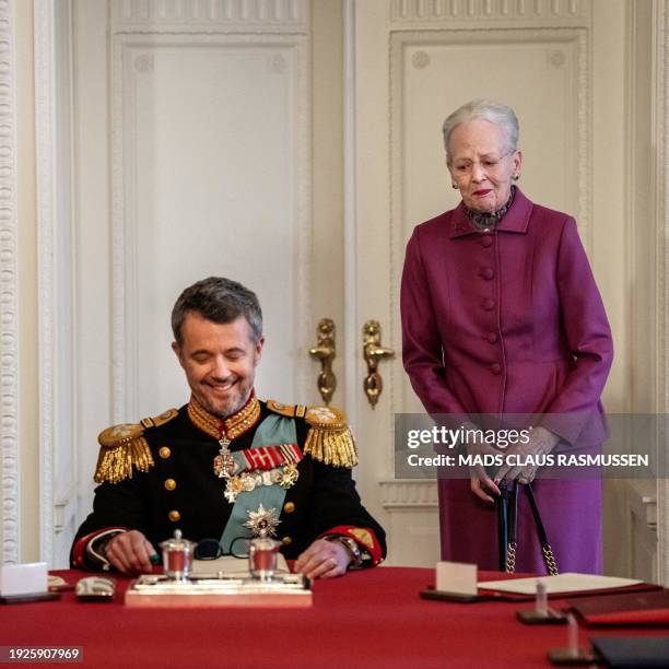 After signing the declaration of abdication Queen Margrethe II of Denmark leaves the seat at the head of the table to her son King Frederik X of...