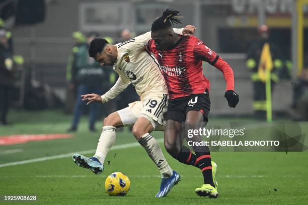 Roma's Turkish defender Mehmet Zeki Celik fights for the ball with AC Milan's Portuguese forward Rafael Leao during the Italian Serie A football...