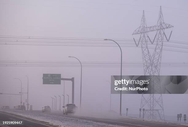 Network of electric polles with wires seen in South Edmonton on a very cold Sunday morning with frost at -40°C and ice fog, on January 14 in...