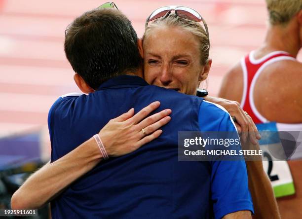 Marathon world record holder Britain's Paula Radcliffe reacts in the arms of Gary Lough, her husband, after she finished 23rd of the 2008 Beijing...