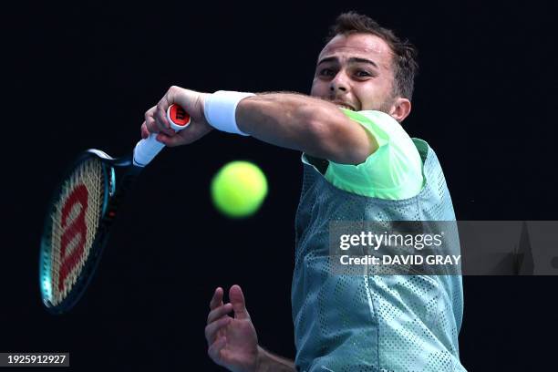 France's Hugo Gaston hits a return against Spain's Roberto Carballes Baena during their men's singles match on day two of the Australian Open tennis...