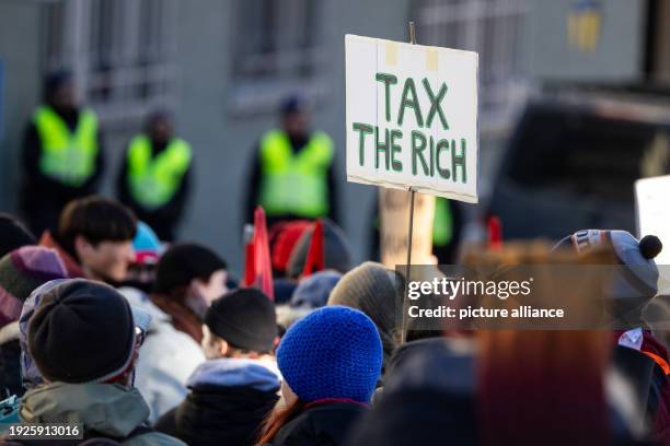 January 2024, Switzerland, Davos: A sign reads "Tax the richt". Hundreds of people demonstrated for climate justice under the title "Strike WEF" in...