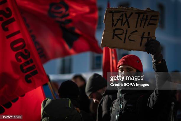 Protester holds a placard during a rally against the 54th World Economic Forum. Hundreds of protesters gathered to voice concerns about this year's...