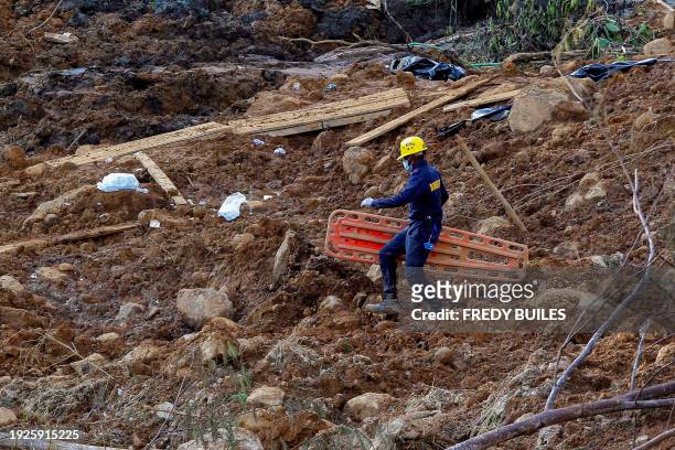 Member of the rescue team walks in the area of a landslide in the road between Quibdo and Medellin, Choco department, Colombia on January 14, 2024....