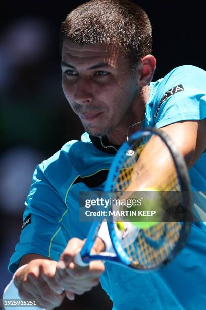 Australia's Alexei Popyrin hits a return against compatriot Marc Polmans during their men's singles match on day two of the Australian Open tennis...