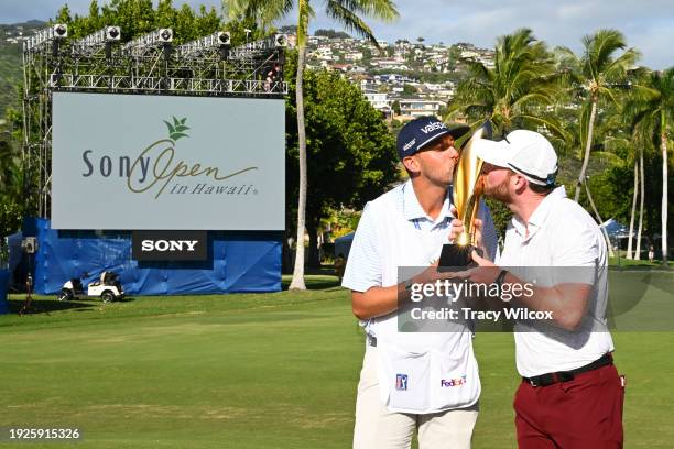 Grayson Murray kisses the trophy with his caddie, Jay Green, after winning the Sony Open in Hawaii at Waialae Country Club on January 14, 2024 in...