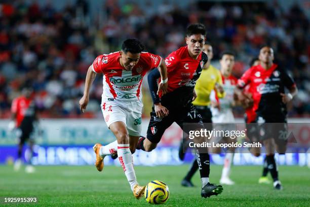 Ricardo Monreal of Necaxa runs with the ball past Jose Lozano of Atlas during the 1st round match between Necaxa and Atlas as part of the Torneo...