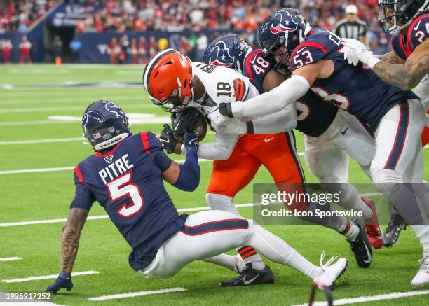 Cleveland Browns wide receiver David Bell gets tackled by Houston Texans safety Jalen Pitre , Houston Texans linebacker Christian Harris , and...