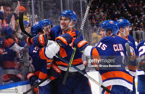 Mathew Barzal of the New York Islanders scores the game-winning goal at 21 seconds of overtime against the Toronto Maple Leafs and is embraced by...
