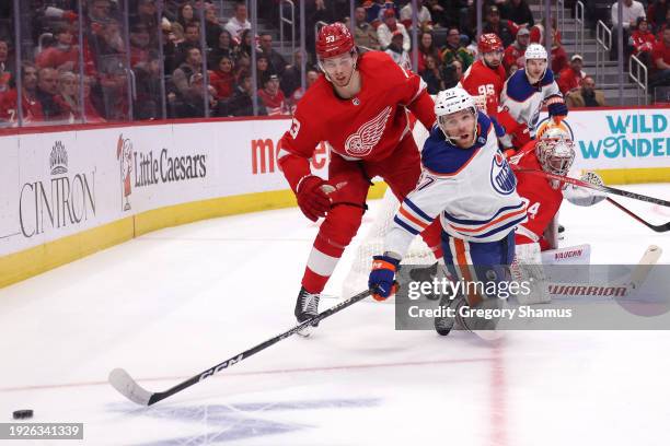 Connor McDavid of the Edmonton Oilers battles for the puck in front of Moritz Seider of the Detroit Red Wings during the third period at Little...