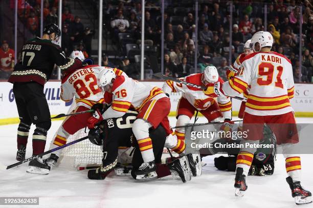 Lawson Crouse of the Arizona Coyotes and Martin Pospisil of the Calgary Flames battle for position as the teams come together in a scrum during the...