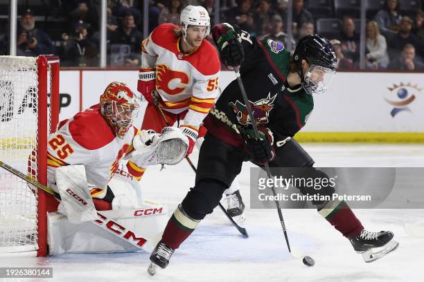 Matias Maccelli of the Arizona Coyotes attempts a shot on goaltender Jacob Markstrom of the Calgary Flames during the second period of the NHL game...