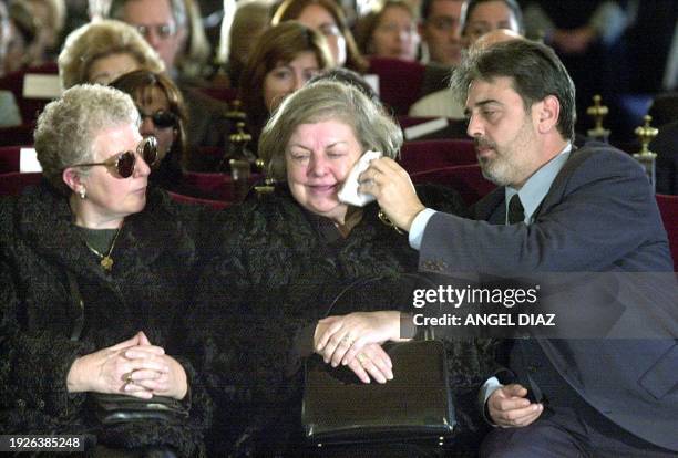 The son of Spanish Supreme Court judge Jose Francisco Querol wipes away tears from the face of his mother while the widow of killed driver Armando...