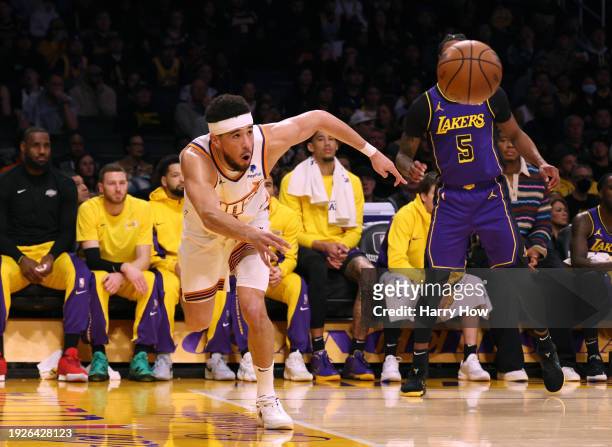 Devin Booker of the Phoenix Suns saves a ball from going out of bounds in front of Cam Reddish of the Los Angeles Lakers during the first half at...