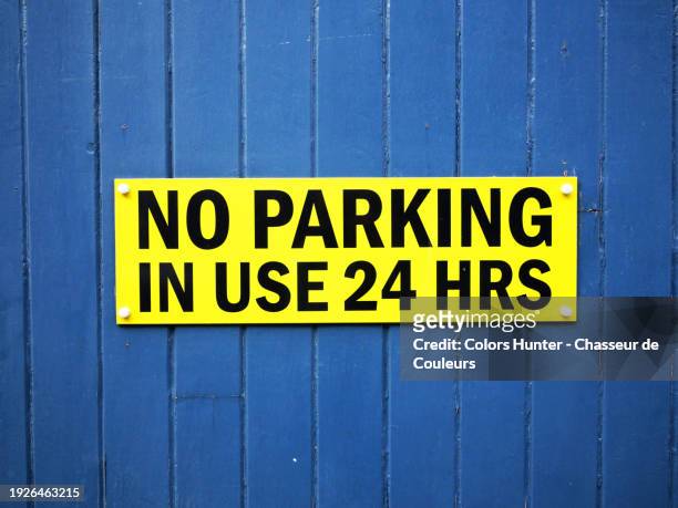 no parking sign on the garage door of an house in london, england, united kingdom. sunlight. natural colors. - door sign stock pictures, royalty-free photos & images