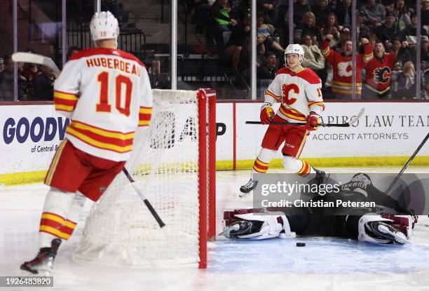 Yegor Sharangovich of the Calgary Flames celebrates with Jonathan Huberdeau after scoring a goal against goaltender Connor Ingram of the Arizona...