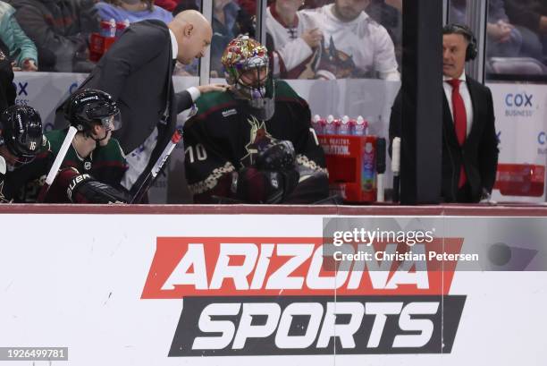 Head coach Andre Tourigny of the Arizona Coyotes talks with goaltender Karel Vejmelka after being removed during the first period of the NHL game...