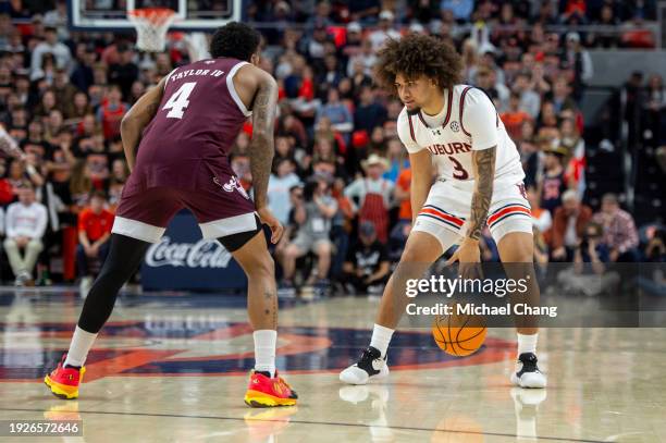 Tre Donaldson of the Auburn Tigers looks to maneuver the ball by Wade Taylor IV of the Texas A&M Aggies at Neville Arena on January 09, 2024 in...