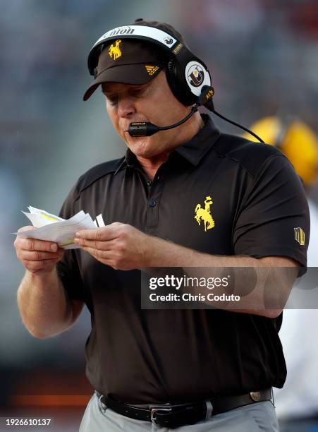 Defensive coordinator Jay Sawvel of the Wyoming Cowboys calls a play during the Barstool Sports Arizona Bowl against the Toledo Rockets at Arizona...