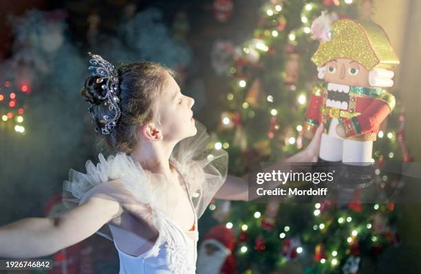 beautiful preteen girl ballet dancer is holding the nutcracker on her hands - childrens ballet recital stock pictures, royalty-free photos & images