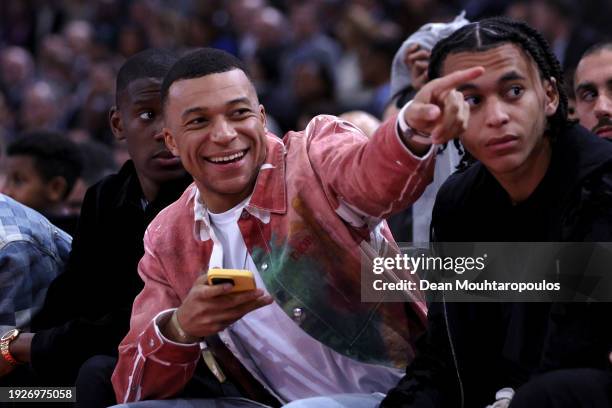 Nordi Mukiele, Kylian Mbappe and Ethan Mbappe speak during the NBA match between Brooklyn Nets and Cleveland Cavaliers at The Accor Arena on January...