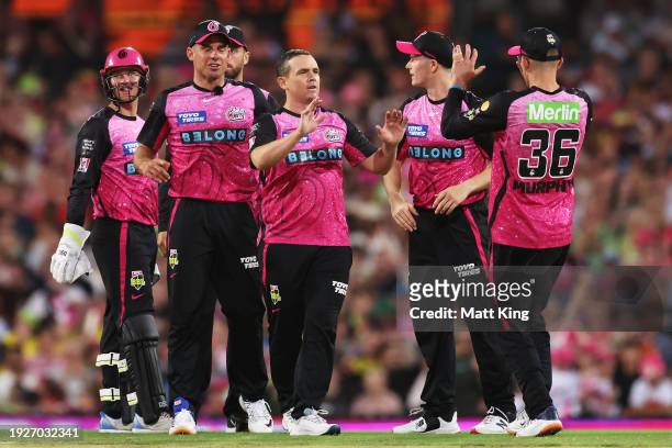 Stephen O’Keefe of the Sixers celebrates with team mates after taking the wicket of Cameron Bancroft of the Thunder during the BBL match between...