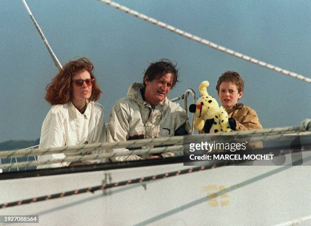 Skipper Olivier de Kersauson, accompanied by his wife Caroline and their son Arthur, poses for photographers after his arrival into the Brest harbor...
