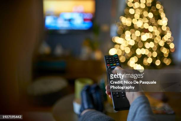 hand of woman pointing remote control at working television screen - photo de film stock pictures, royalty-free photos & images
