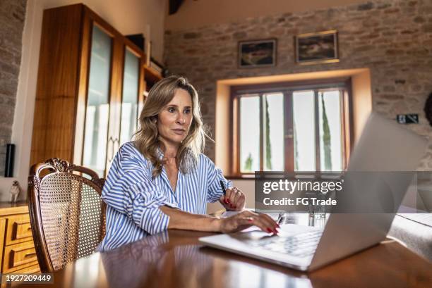 mature woman using the laptop at home - generation x stock pictures, royalty-free photos & images