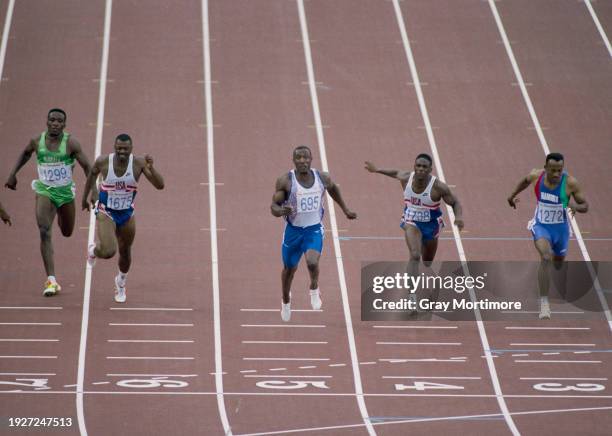 Linford Christie of Great Britain crosses the finish line to win the Men's 100 metres race from silver medal winner Frankie Fredericks of Namibia and...