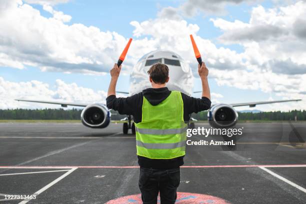 flugzeuge befolgen die anweisungen des bodenpersonals am flughafen - airport ground crew uniform stock-fotos und bilder