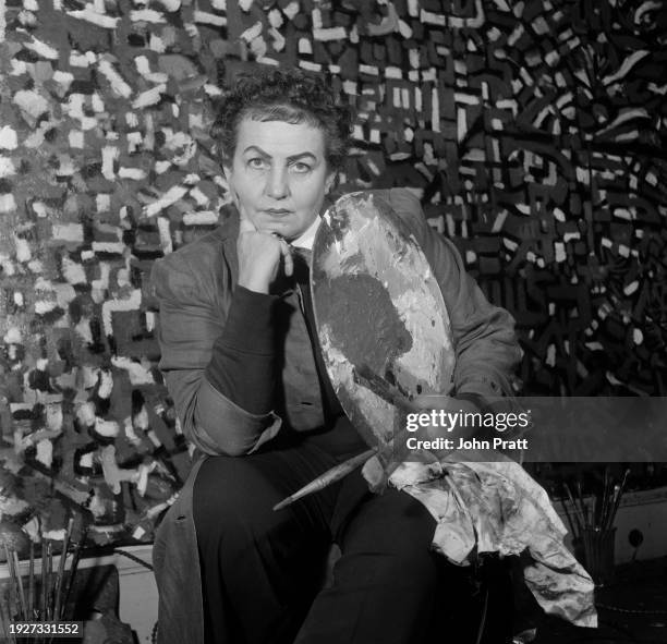 Turkish painter Princess Fahrelnissa Zeid seated in her studio at the Iraqi embassy in Kensington Palace Gardens, London, August 1954. Zeid is the...