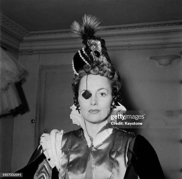 British-American actress Olivia de Havilland wearing her costume and eye patch from the film 'That Lady', September 1954.